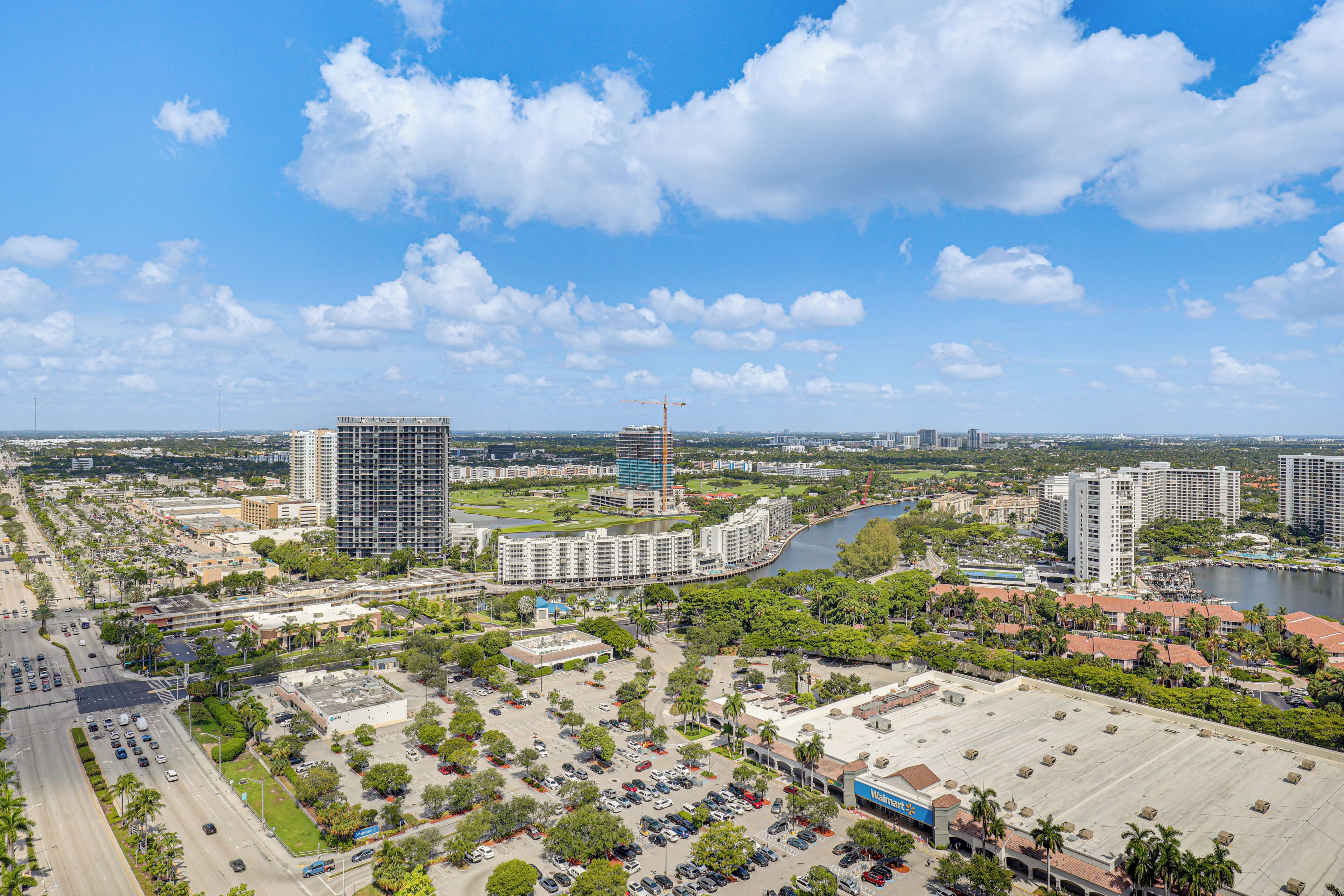 Une vue urbaine avec de hauts immeubles, une rivière et un magasin Walmart.