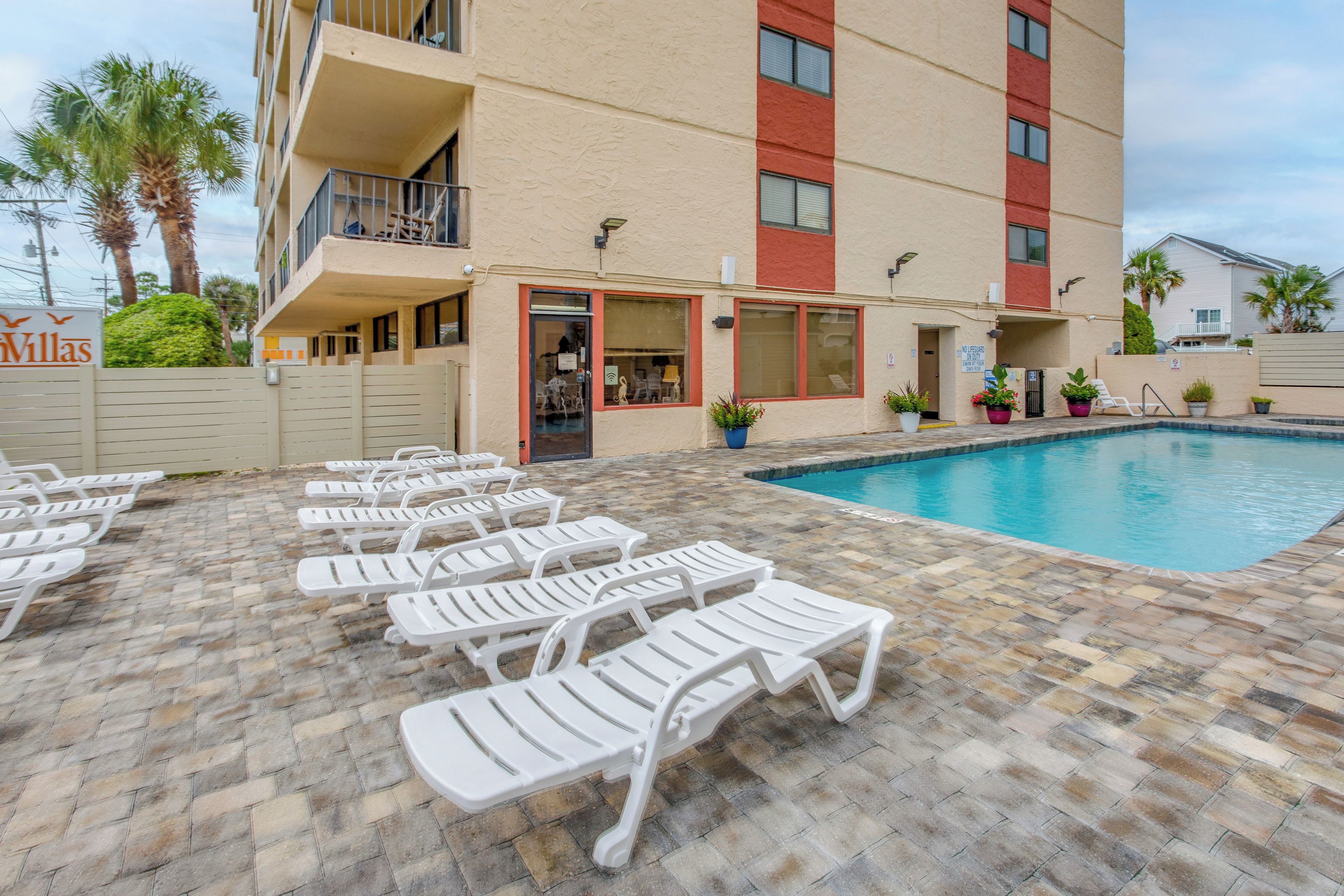 A poolside area with lounge chairs and a swimming pool.