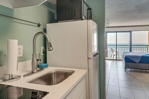A compact kitchenette with a sink, faucet, and a small refrigerator. - 14th-floor Ocean View + Pools! Myrtle Beach Haven (Myrtle Beach)