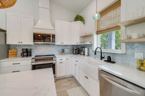 A modern kitchen with white cabinetry, a stainless steel dishwasher, and a built-in oven. - Fort Morgan Hideaway Hot Tub Golf Beach Access (Gulf Shores)