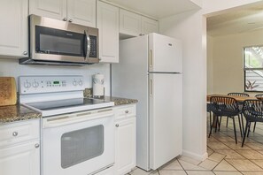 Una cocina equipada con microondas, horno y refrigerador.