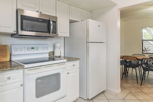Una cocina equipada con microondas, horno y refrigerador.