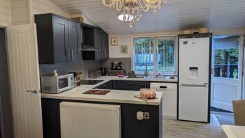 A modern kitchen with a central island, built-in appliances, and a large window providing natural light.