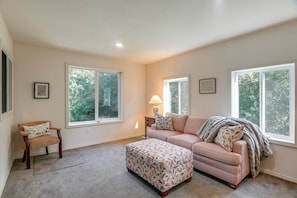 A spacious living room with a large window, a sofa, an ottoman, and a chair. - 1 Mi to Dtwn Driggs! Secluded Escape w/ Yard (Driggs)