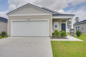 A single-story house with a garage, a front porch, and a small front yard.