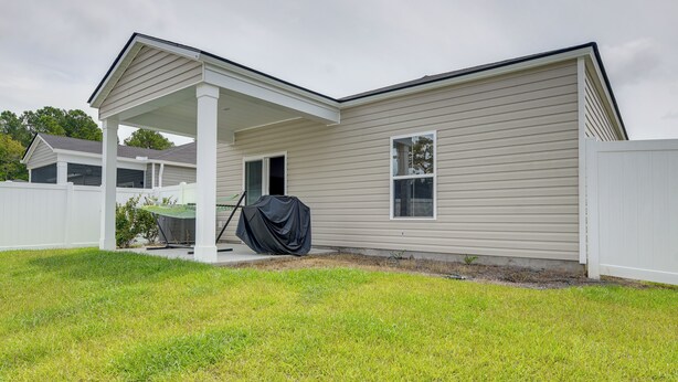 A single-story house with a covered porch, a small window, and a white fence.