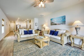 A spacious living room with two sofas, a coffee table, and a ceiling fan.