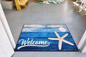 Eine Fußmatte mit einem 'Welcome'-Schild und einem Seestern-Design.