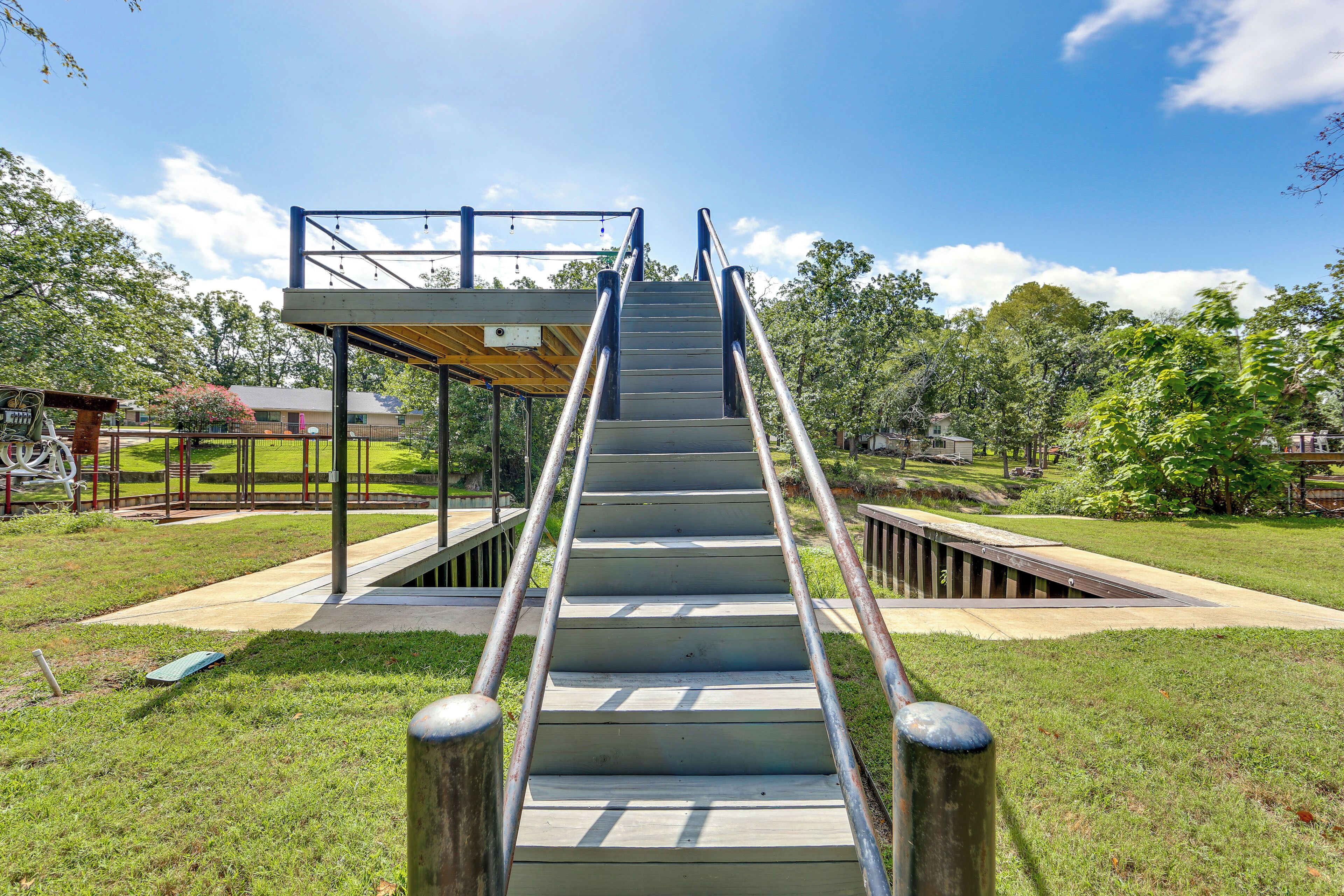 A set of outdoor stairs leading to a covered area with metal railings.