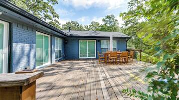 A blue house with a deck, a table, and chairs.