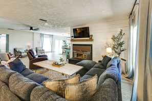 Ein modernes Wohnzimmer mit Kamin, Fernseher und Essbereich.