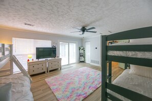 A bedroom with bunk beds, a television, a dresser, and a ceiling fan. - Dock & Golf at Cedar Creek! 'shoreline Retreat' (Malakoff)
