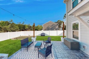 A patio with outdoor furniture, a small pool, and a white fence.