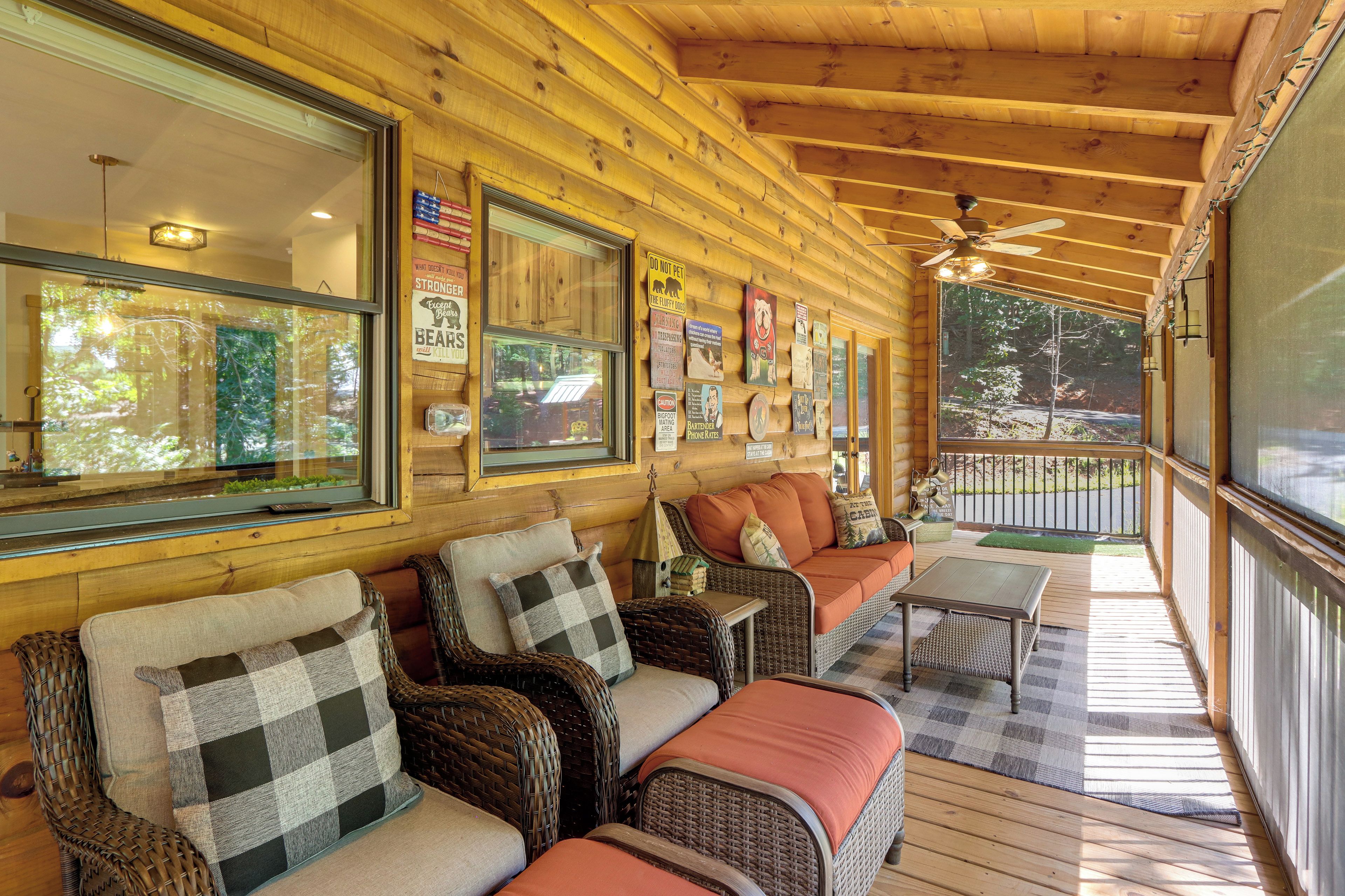A wooden cabin with a covered porch, wicker furniture, and various signs.