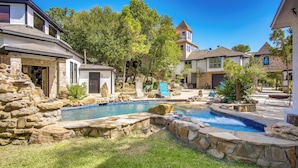 Un barrio residencial con piscina, muros de piedra y casas de diversos estilos arquitectónicos.