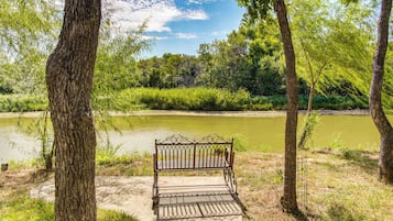A bench in a park with a river in the background.