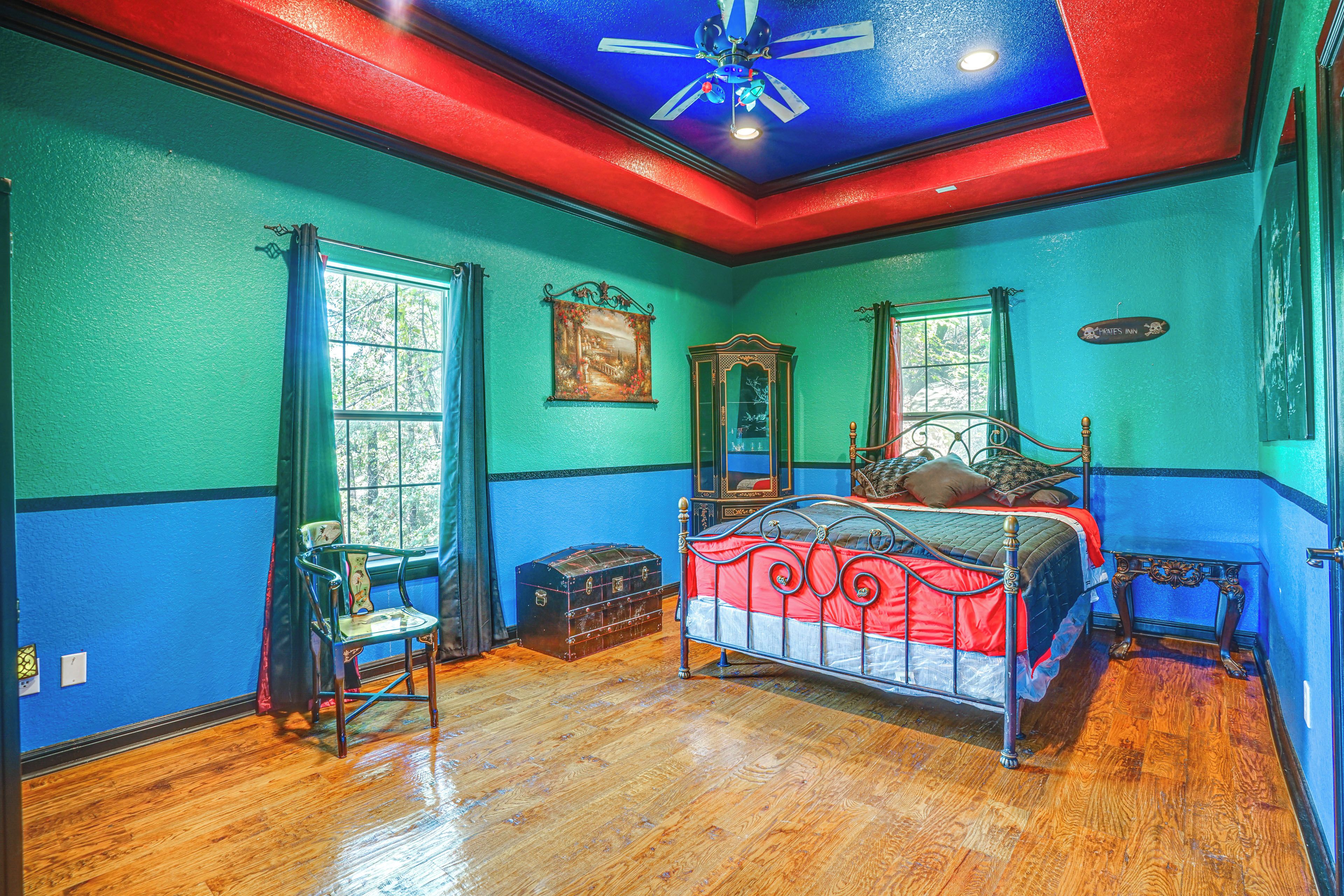 A room with a bed, a chest of drawers, a chair, and a window.