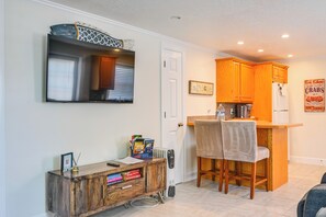 A compact kitchen with wooden cabinets, a built-in microwave, and a small dining area with two chairs. - 2 Mi to Beach! Naples Park Bungalow (Naples)