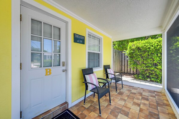 A yellow exterior wall with a door marked with a 'B' and a sign reading 'The Cozy est. 2009'. - 2 Mi to Beach! Naples Park Bungalow (Naples)