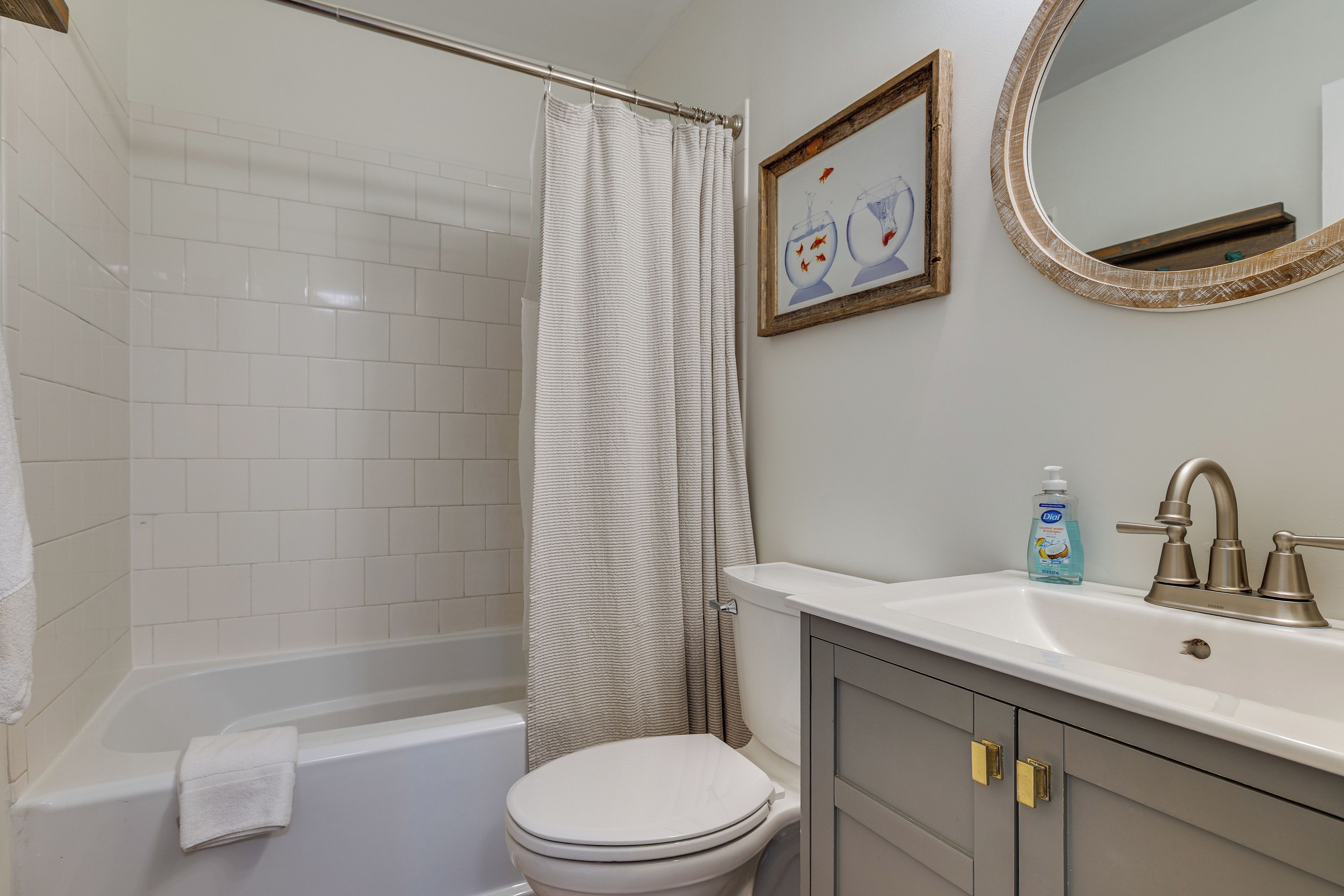 A bathroom with a bathtub, toilet, and a sink with a mirror above it.