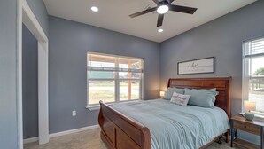 A bedroom with a bed, a ceiling fan, a window with blinds, and a wall-mounted sign. - Gateway to State Park & Lake! Inviting Vian Cabin (Gore)