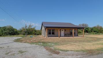 A small, single-story building with a flat roof and a porch.