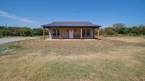 A single-story house with a covered porch, a front door, and a garage. - Gateway to State Park & Lake! Inviting Vian Cabin (Gore)