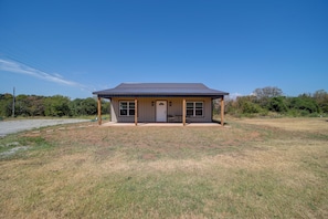 A single-story house with a covered porch, a front door, and a garage.