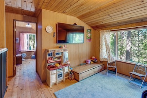 L’intérieur d’une cabane en bois comprend un espace cuisine, une grande fenêtre et une vue sur l’extérieur.