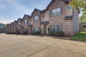 A row of townhouses with brick exteriors, uniform window designs, and a clear sky. - Walk to Campus! Auburn Escape w/ Grill (Auburn)