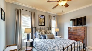 A bedroom with a bed, a dresser, a television, and a ceiling fan. - Walk to Campus! Auburn Escape w/ Grill (Auburn)