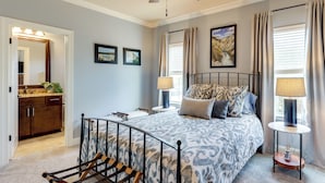 A bedroom with a bed, bedside tables, a ceiling fan, and a bathroom with a sink and mirror. - Walk to Campus! Auburn Escape w/ Grill (Auburn)