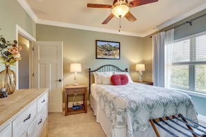 A bedroom with a bed, two bedside tables, a ceiling fan, a window with blinds, a door, and a dresser. - Walk to Campus! Auburn Escape w/ Grill (Auburn)