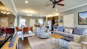 A spacious living room with a sofa, chairs, a dining area, and a kitchen. - Walk to Campus! Auburn Escape w/ Grill (Auburn)