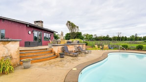 A swimming pool with a red building and outdoor seating area. - 6,000-sq-ft Estate in Delaware River Valley (Milford)