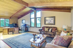 A spacious living room with a high ceiling, large windows, a fireplace, a coffee table, and a comfortable seating area. - 6,000-sq-ft Estate in Delaware River Valley (Milford)