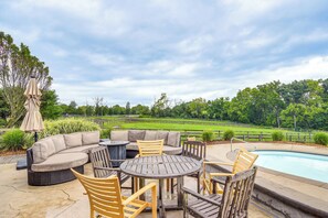 An outdoor patio with a pool, seating area, and a view of a green landscape. - 6,000-sq-ft Estate in Delaware River Valley (Milford)