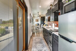 A modern kitchen with a large refrigerator, stove, and dining area. - River Views & Rural Charm: Springfield Retreat (Springfield)
