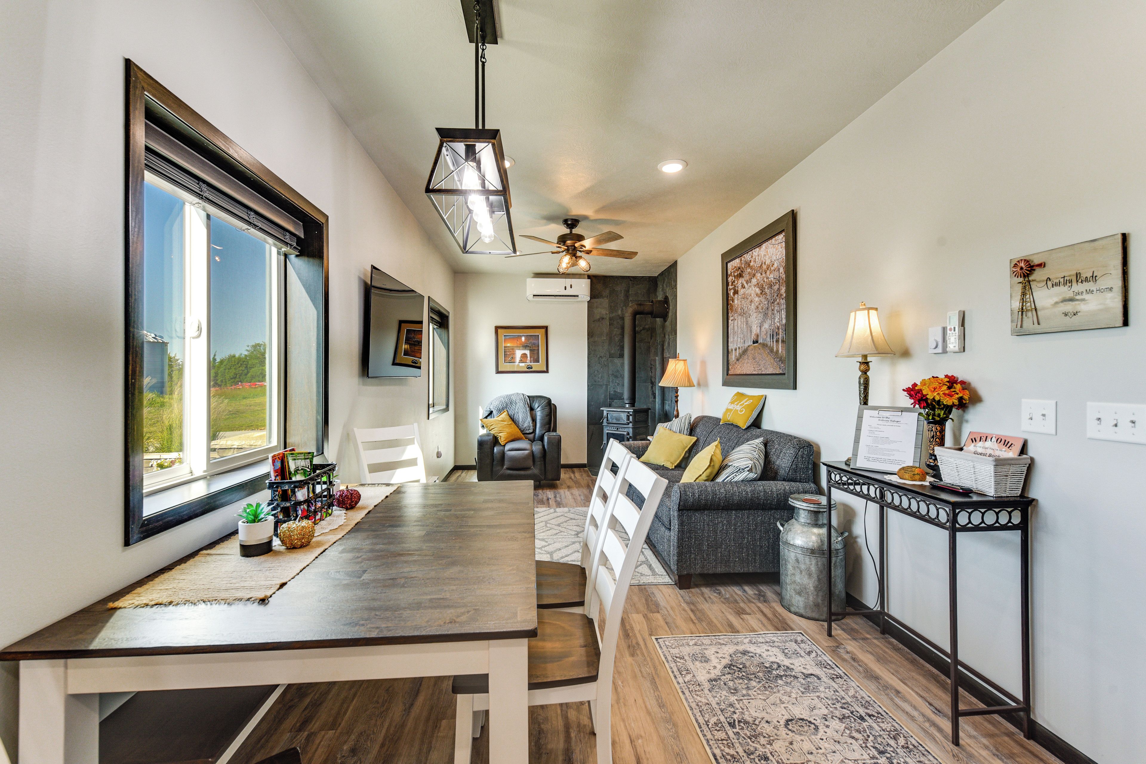 A spacious living area with a dining table, a sofa, and a fireplace.