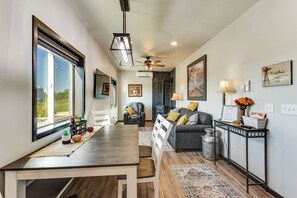 A spacious living area with a dining table, a sofa, and a fireplace.