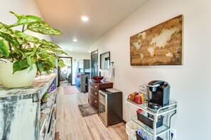 A hallway with a wooden floor, a potted plant, a coffee machine, and a map on the wall. - River Views & Rural Charm: Springfield Retreat (Springfield)