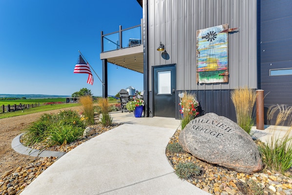 A modern building with a large rock inscribed with 'ALLVIEW REFUGE EST. 2025' in front.