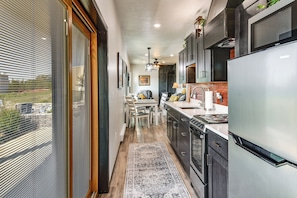 A modern kitchen with a large refrigerator, stove, and dining area.