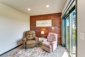 A room with two leather armchairs, a framed picture on the wall, and a lamp on a small table.
