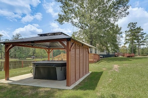 A covered outdoor area with a hot tub, a wooden deck, and a view of a lake. - Waterfront Retreat Fishing, Hot Tub & Sauna (Harlem)