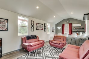 A spacious living area with two leather sofas, a patterned rug, and a kitchen area with bar stools. - Waterfront Retreat Fishing, Hot Tub & Sauna (Harlem)