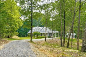 A house with a gravel driveway, surrounded by trees and a well-maintained lawn. - Private Woodland Garden Retreat in Ethelsville (Ethelsville)