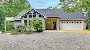 A two-story house with a garage, a front porch, and a landscaped front yard. - Private Woodland Garden Retreat in Ethelsville (Ethelsville)