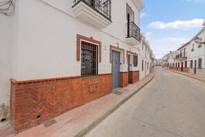 Eine Straße mit weißen Gebäuden, roten Backsteingrundmauern und Metallgittern.