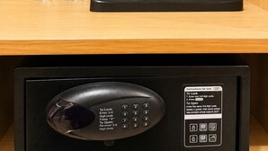 A hotel minibar with bottled water, a coffee maker, a sugar packet, and a remote control. - Hotel Lumen - A Garden of Lights (Pokhara)